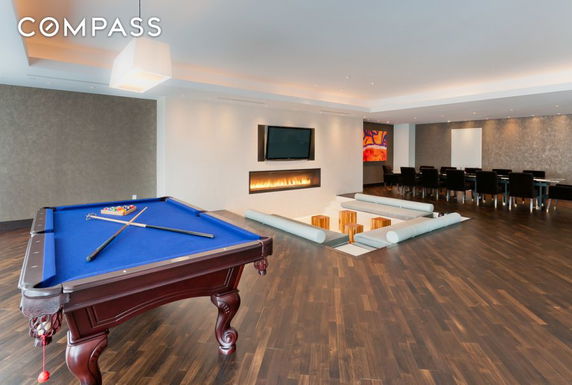 Interior view of a recreation room with a pool table and seating area.