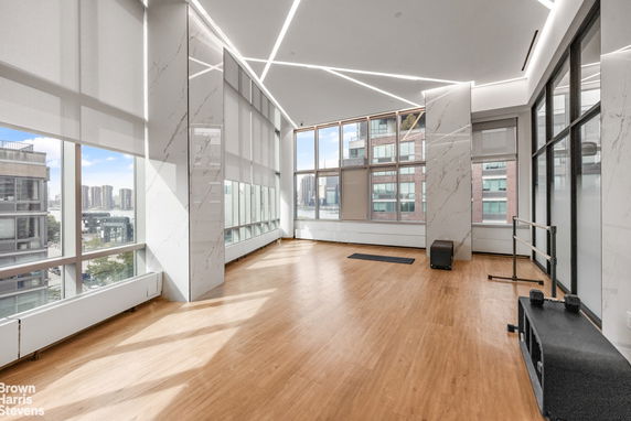 Modern indoor gym area with large windows and wooden floor