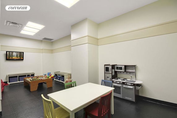 Indoor play area with children's furniture and toys.