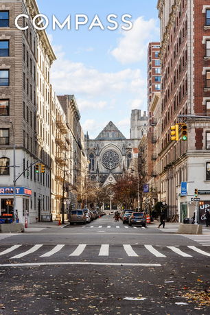 Front view of a large cathedral surrounded by urban buildings