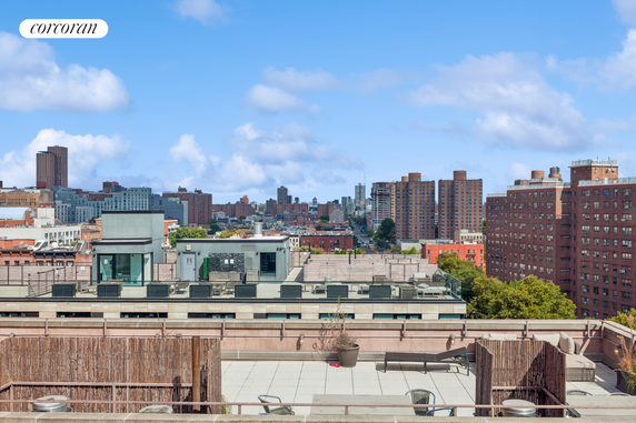 Rooftop with seating area and views of surrounding city buildings.