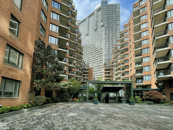 Front view of a multi-story apartment building with a modern glass entrance.