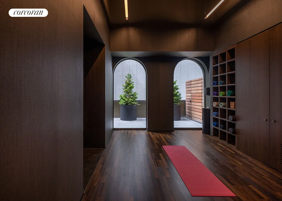 Interior view of a yoga studio with wooden floors and arched windows.