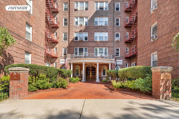 Front view of a multi-story brick apartment building with a central entrance.