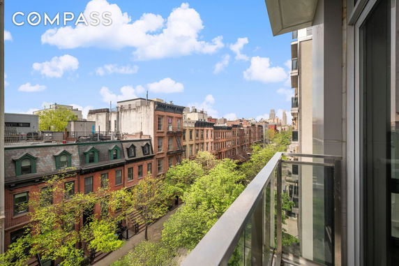 Panoramic view of a city street with brick buildings and trees.