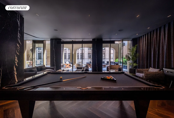 Interior view of a recreational room featuring a pool table and seating area.