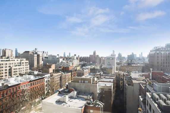 Panoramic view of cityscape with buildings under a clear blue sky.