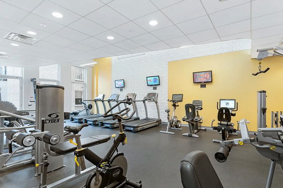 Indoor gym with various exercise machines and equipment.