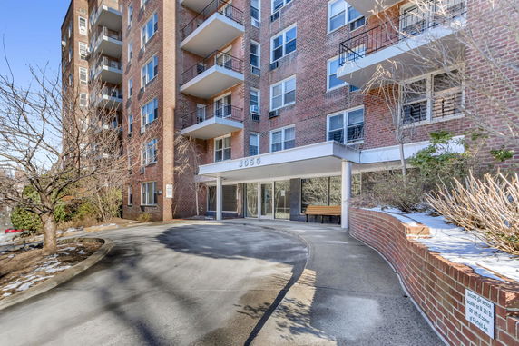 Front view of a multi-story apartment building with balconies and entrance.