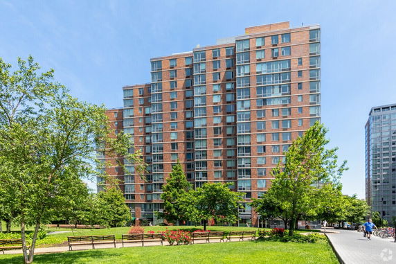 Front view of a multi-story apartment building with many windows.