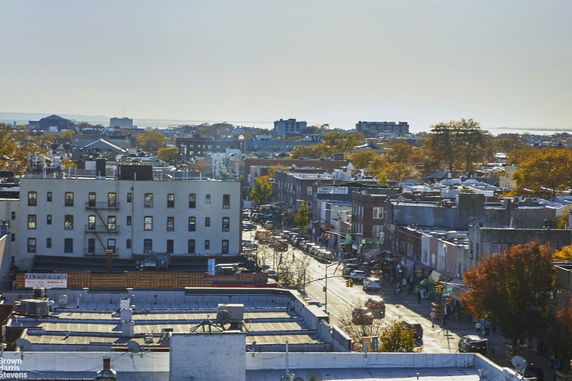 Panoramic view of a cityscape with various buildings and a busy street.