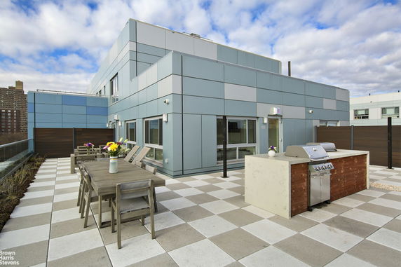 Rooftop with a modern outdoor seating area and a barbecue grill.