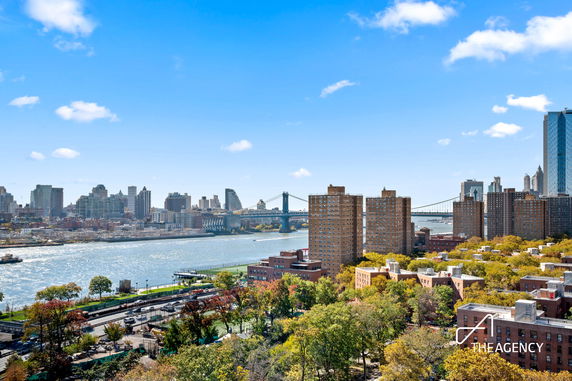 Panoramic view of a cityscape with river, skyscrapers, and bridges.