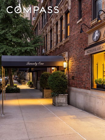 Front view of a multi-story brick building with decorative arches and a canopy entrance.
