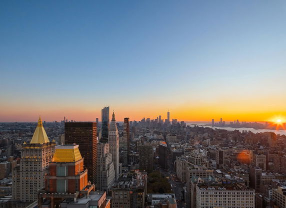 Panoramic view of a city skyline with skyscrapers at sunset.