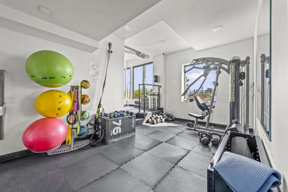 Indoor gym area with exercise equipment and colorful exercise balls.