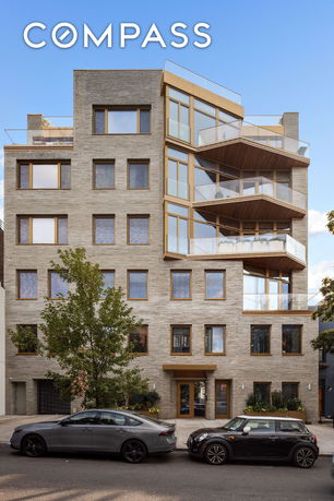 Front view of a multi-story building with large windows and balconies.