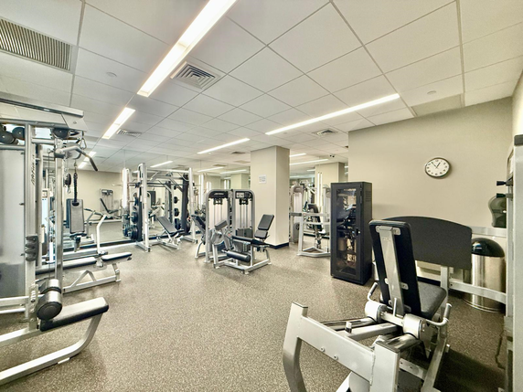 Interior view of a gym with various exercise machines and equipment.