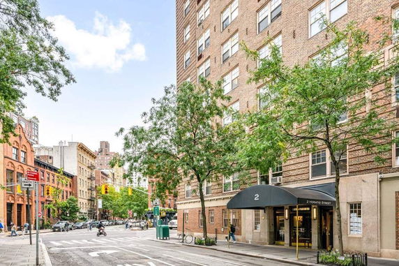 Front view of a multi-story brick building on a street corner.