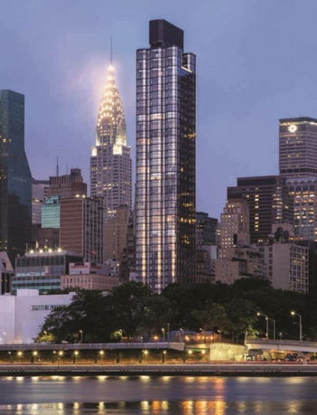 Front view of a tall skyscraper among other city buildings.