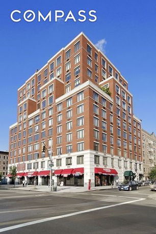 Front view of a multi-story brick building on a street corner.
