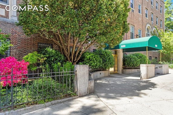 Front view of a multi-story brick building with a green canopy entrance.