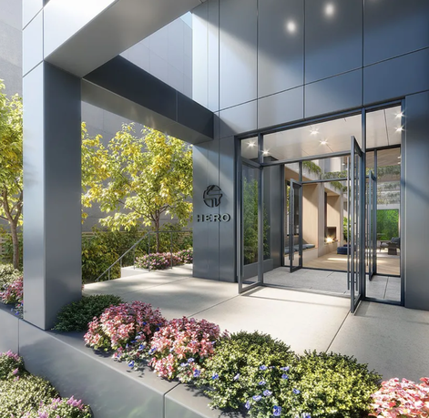 Entrance view of a modern building with glass doors and a sleek facade.