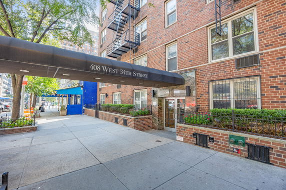 Front view of an apartment building with a covered entrance canopy.