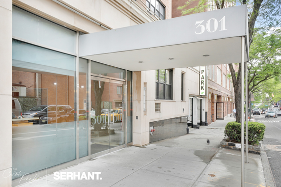 Front view of a building entrance with glass doors and overhead canopy displaying the number 301.