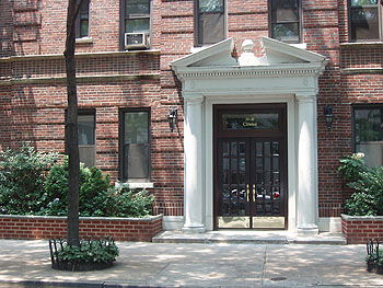 Front view of a brick building with a decorative entryway.