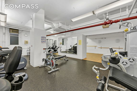 Indoor gym area with exercise equipment and mirrors.