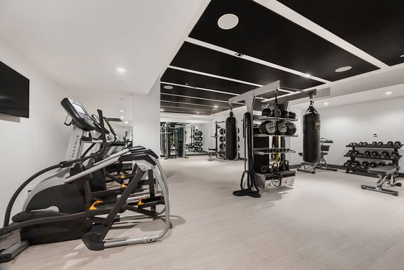 Interior of a gym with exercise equipment and weights.