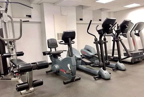Indoor gym area with exercise equipment including bikes and treadmills.