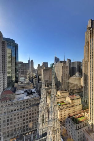 Skyline view of a city with multiple skyscrapers and a prominent cathedral in the foreground.