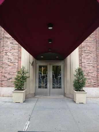 Front view of a building entrance with double doors and an overhead canopy.
