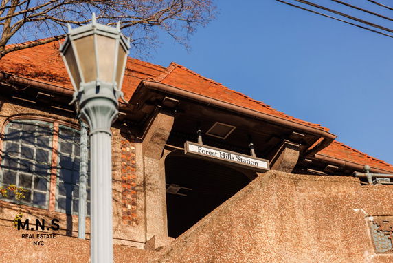 Front view of a building with a sign indicating Forest Hills Station.