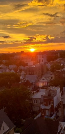 Panoramic view of rooftops and buildings at sunset.