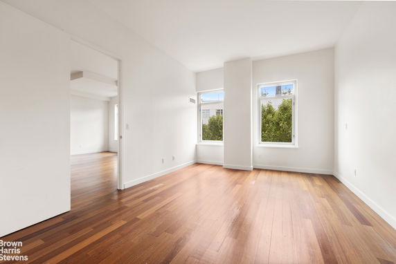 Squash court indoors with a glass back wall and wooden flooring.