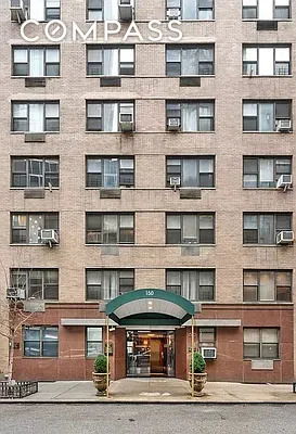Front view of a multi-story apartment building with a green awning at the entrance.