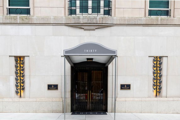 Front view of a building entrance with a decorative canopy labeled 'Thirty'.