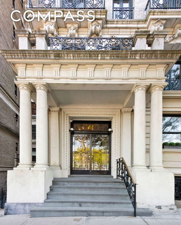 Front view of a building with decorative columns and intricate balcony railings.