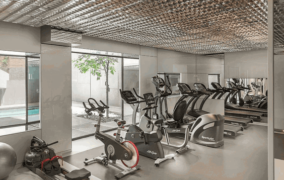 Indoor gym area with exercise equipment including stationary bikes and treadmills.