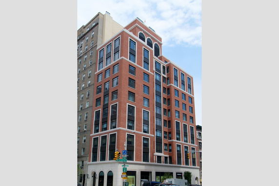 Front view of a multi-story brick building with large windows.