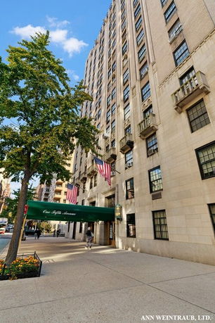Front view of a tall multi-story building with a green canopy at the entrance.