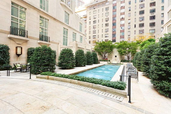 Swimming pool area in an outdoor courtyard of a multi-story building.