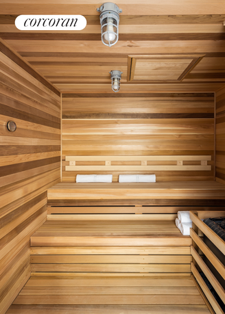 Interior view of a wooden sauna room with tiered seating and towels.