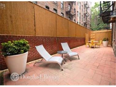 Outdoor patio area with lounge chairs and a table.