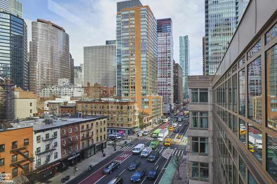 View of cityscape featuring multiple high-rise buildings and a busy street with traffic.