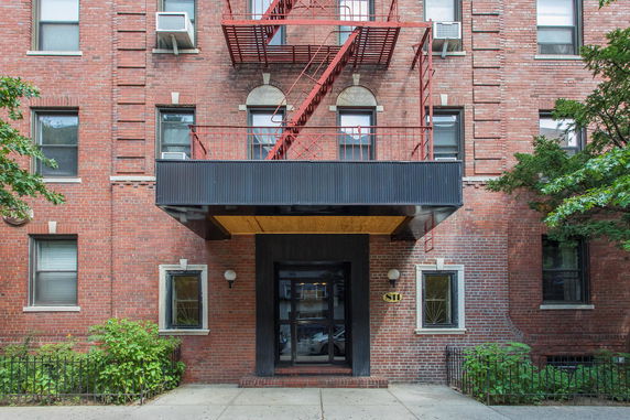 Front view of a brick apartment building with a fire escape.