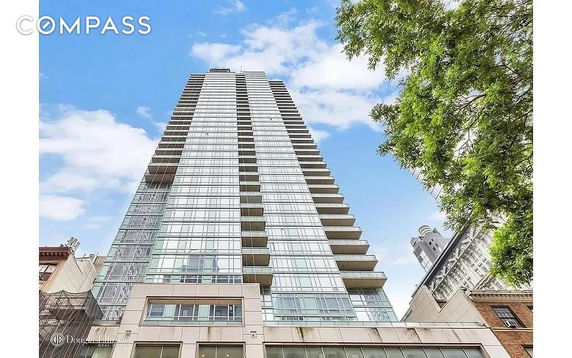 Front view of a tall modern apartment building with glass facades.
